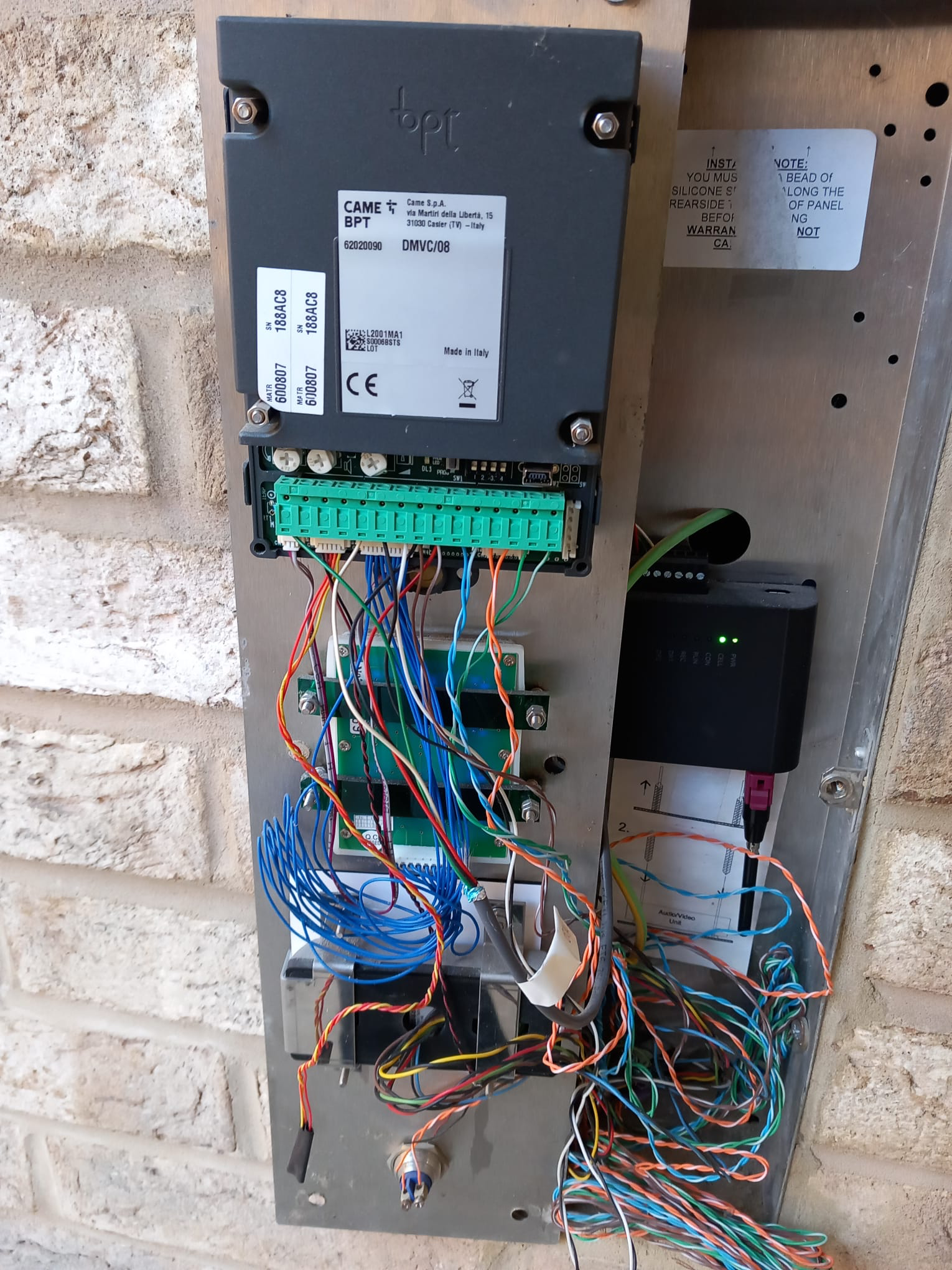 Door entry intercom control panel with wiring exposed.